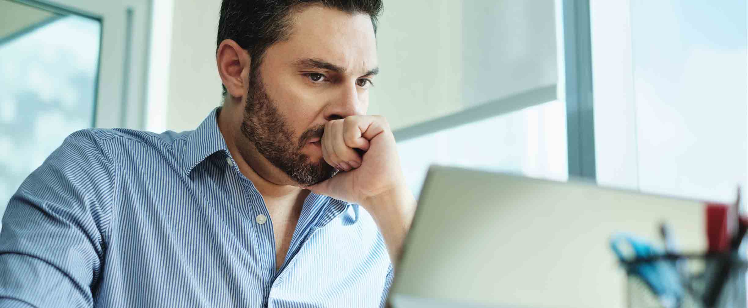 Worried Businessman Looking at Laptop Computer