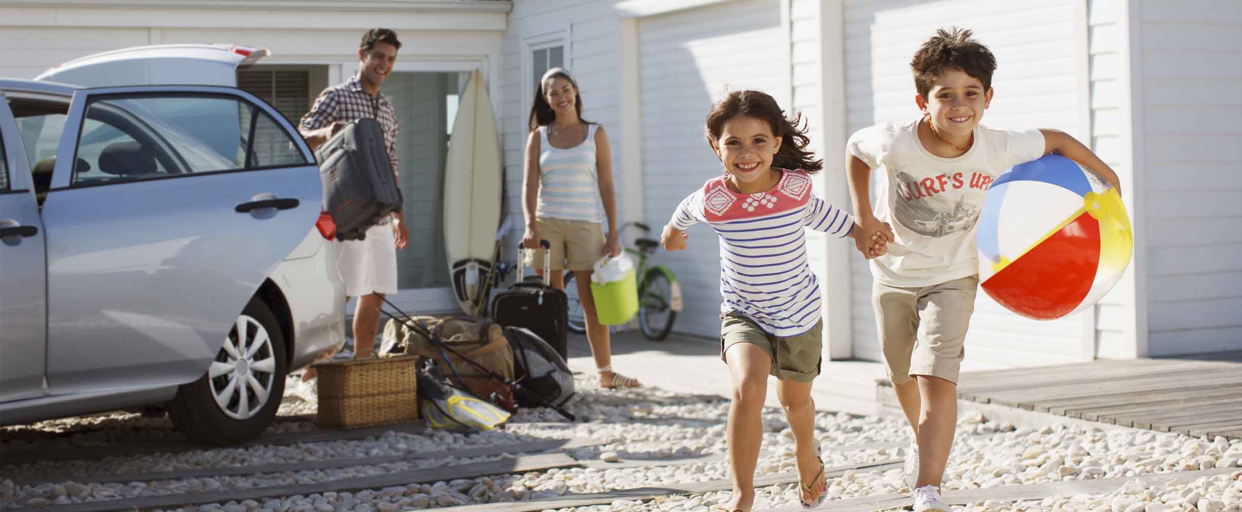 young family getting out of their car at their beach home