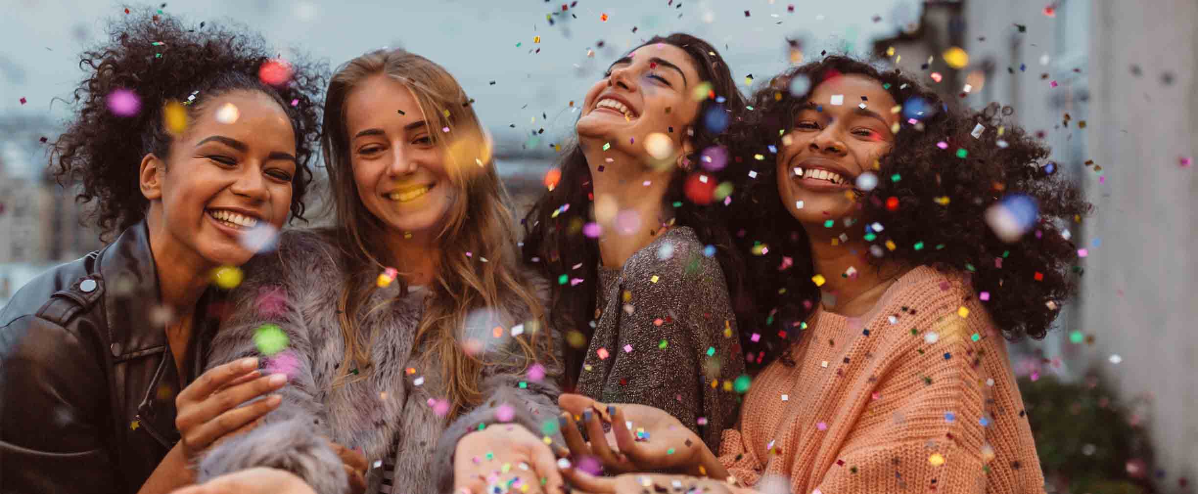 four girls celebrating with confetti