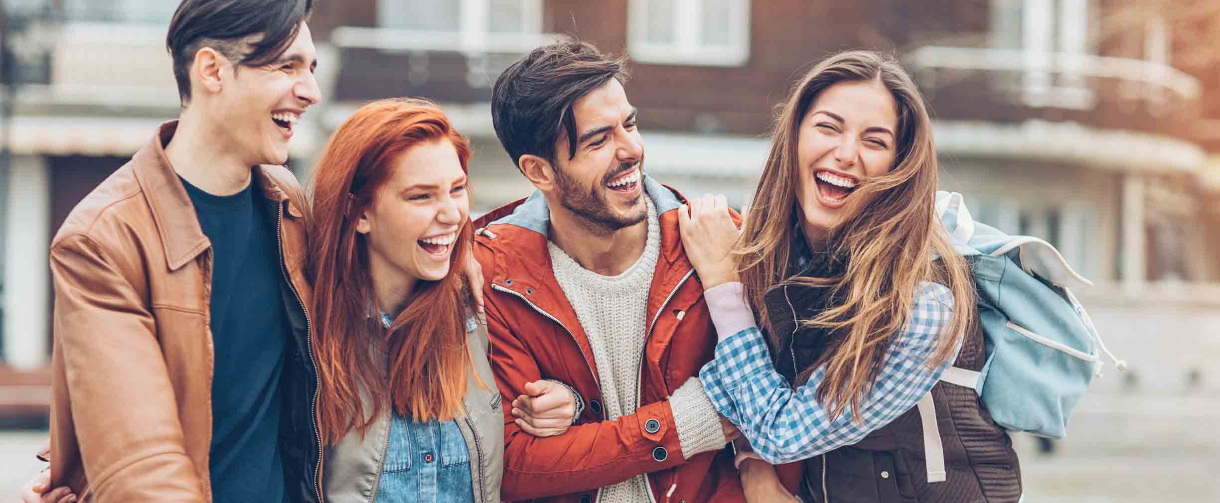 four students walking together and laughing