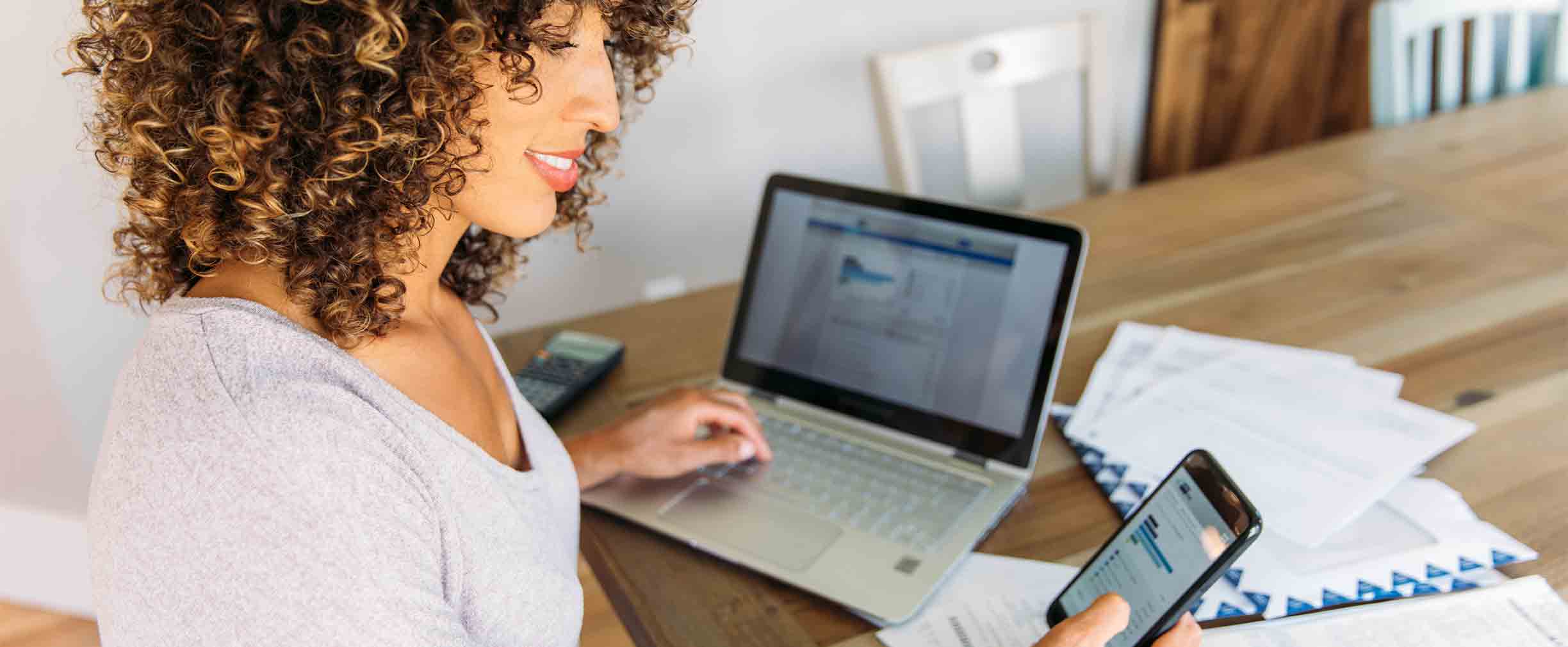 Woman Doing Finances at Home on Smart Phone stock photo