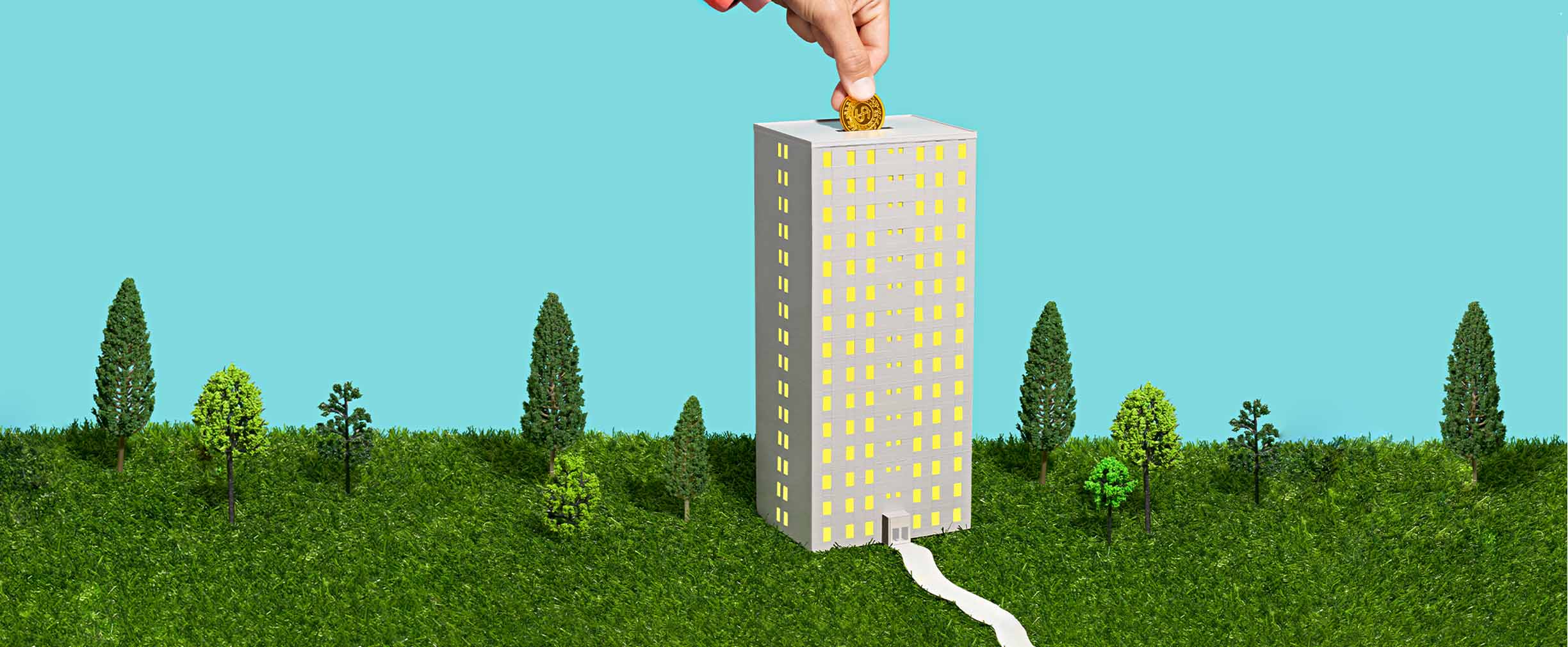 A photo illustration of a high-rise building that is actually a piggy bank with a hand depositing a coin into its roof